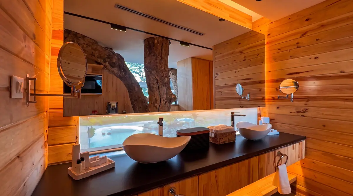 Baño con madera y el árbol atravesando el espacio